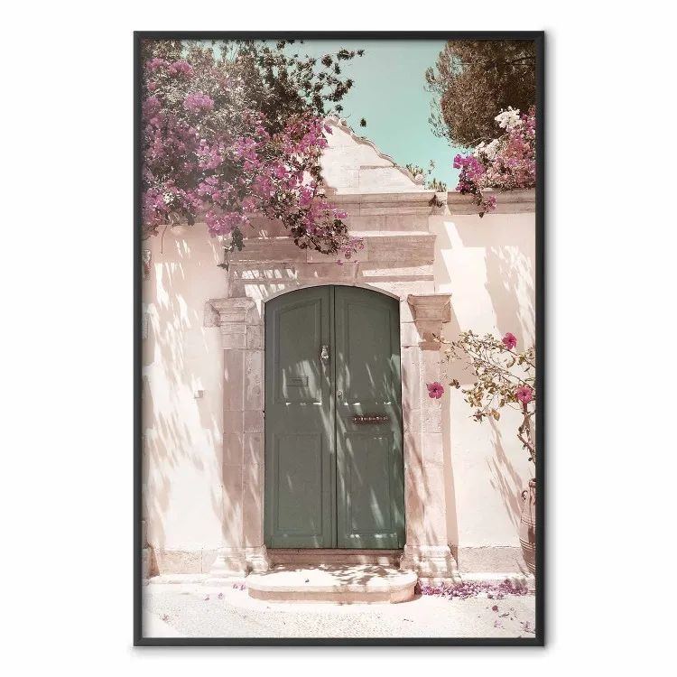 Förtjusande gata - mur med gröndörr och träd med rosa blommor